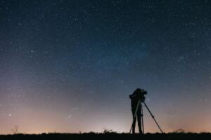 Telescope pointed at a starry night sky